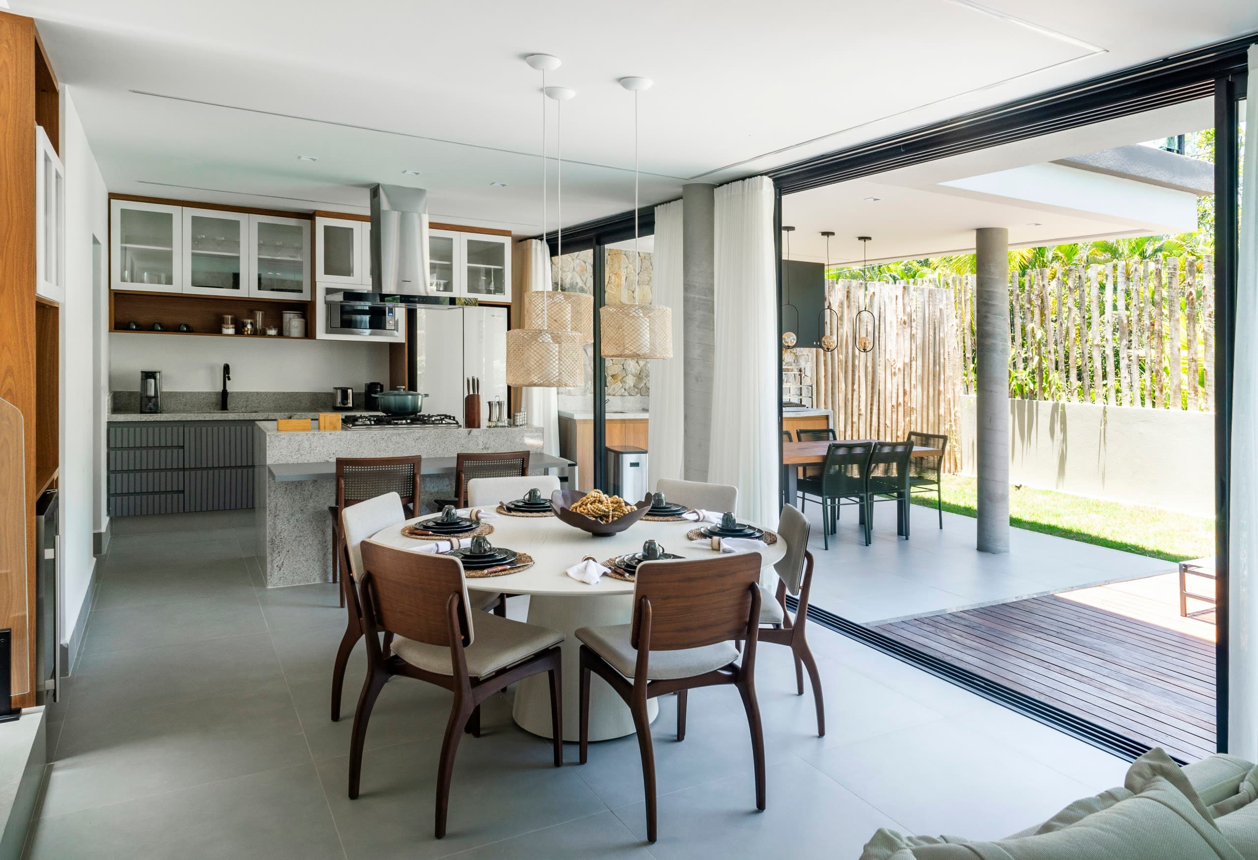 Sala de jantar e cozinha integradas, abertas para o deck